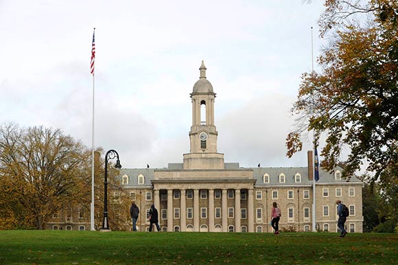 PSU students walk across the campus in front of the Old Main building