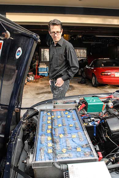 Hollinger inspects the battery cells in his converted SAAB