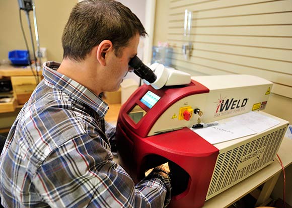 Williams uses a laser to weld metal in his jewelery shop Marc Co Jewelers.