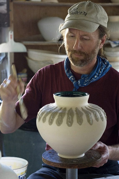 Ceramicist Joe Sendek glazing a vessel in the ceramics studio