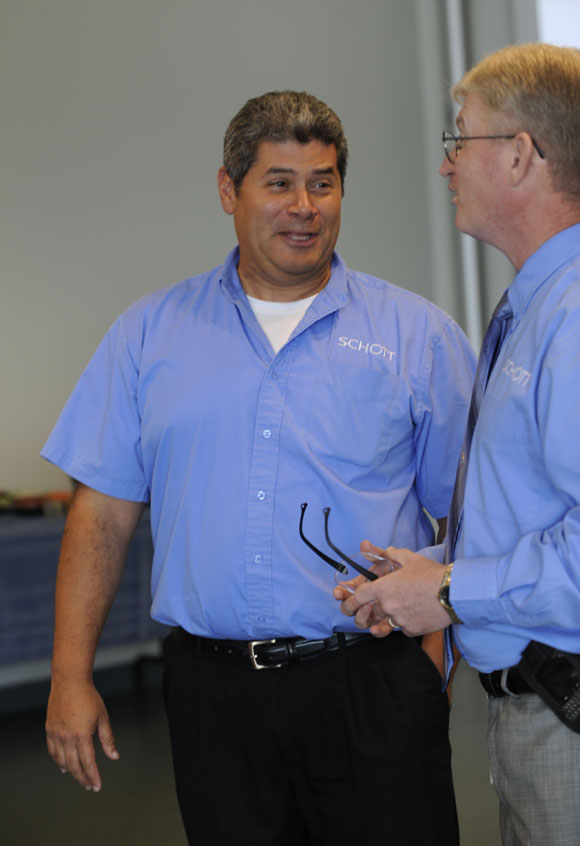 Schott employee Luis Bouril, left, speaks with Gneral Manager Pharmaceutical Packaging Chris Sellards, right.