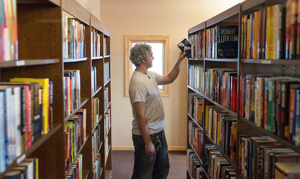 Brian Wolovich peruses the library that he helped to build in Millvale.